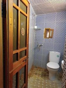 a bathroom with a toilet and a window and a door at Dar Mchachti fes in Fez
