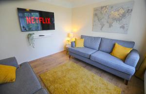 sala de estar con sofá azul y almohadas amarillas en 5Bed House Wirral near Liverpool Chester, en Wirral