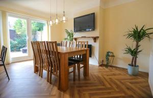 uma sala de jantar com uma mesa de madeira e cadeiras em 5Bed House Wirral near Liverpool Chester em Wirral