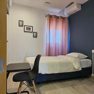 een slaapkamer met een bed, een stoel en een raam bij Marinha Garden Inn in Marinha Grande