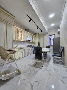 uma grande cozinha com cadeiras e uma mesa em Huvaydo Residence Apartment em Tashkent