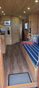 a large room with a bed in a boat at La Roulotte d'Emilie et son jacuzzi privé in Beurlay