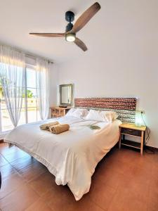 Schlafzimmer mit einem großen Bett und einem Deckenventilator in der Unterkunft Ático 3 dormitorios in Vera