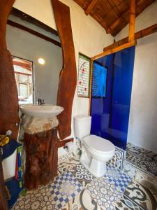 a bathroom with a white toilet and a sink at Cabaña Esmeralda - Seilan Alojamiento Rural in Paipa