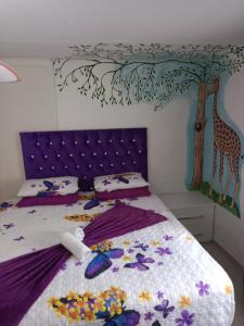 a bedroom with a bed with a giraffe mural on the wall at Love of Sixtus vanue hire and guest house in Johannesburg