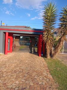 a building with red pillars and a palm tree at Love of Sixtus vanue hire and guest house in Johannesburg