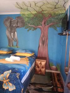 a bedroom with a mural of a tree and an elephant at Love of Sixtus vanue hire and guest house in Johannesburg