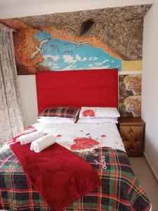a bedroom with a bed with a red head board at Love of Sixtus vanue hire and guest house in Johannesburg