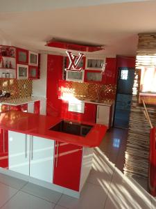 a red kitchen with white cabinets and a red island at Love of Sixtus vanue hire and guest house in Johannesburg