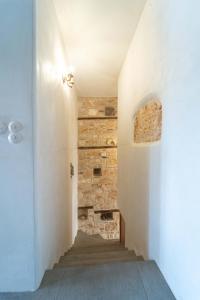 pasillo con escalera y pared de piedra en Marilena en Meyisti