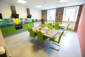 a dining room with a table and green chairs at Honeybee Properties Winningen in Winningen