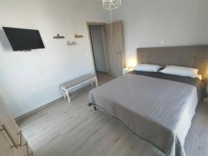 a bedroom with a bed and a flat screen tv at Luxury sea apartment in Loutraki