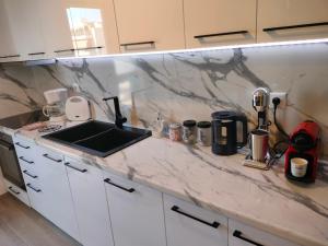 a kitchen with a marble counter top with a sink at Luxury sea apartment in Loutraki