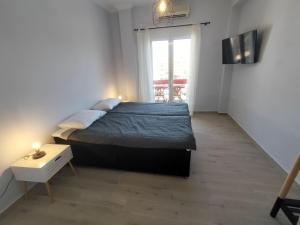 a bedroom with a large bed and a window at Luxury sea apartment in Loutraki