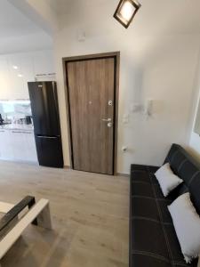 a living room with a black couch and a wooden door at Luxury sea apartment in Loutraki +5 photos