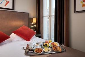 a tray of food on top of a bed at Régence Etoile in Paris