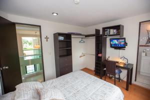 Schlafzimmer mit einem Bett, einem Schreibtisch und einem TV in der Unterkunft Habitación matrimonial con baño propio in Puebla