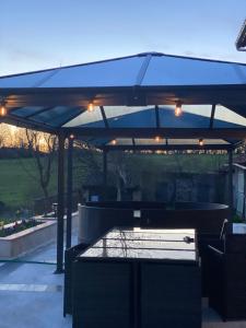 a pavilion with a picnic table and an umbrella at Chambres d'hôtes du Vigeant in Le Vigeant