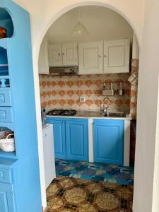 a kitchen with blue cabinets and a tile floor at casa fiorella in San Bernardino