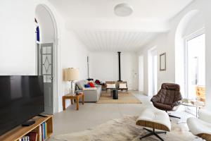 een woonkamer met witte muren en een bank en stoelen bij Casa Rosa in Vila Real de Santo António