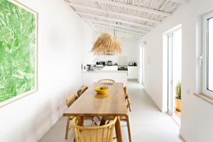 eine Küche und ein Esszimmer mit einem Holztisch und Stühlen in der Unterkunft Casa Rosa in Vila Real de Santo António