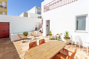 eine Terrasse mit einem Holztisch und Stühlen in der Unterkunft Casa Rosa in Vila Real de Santo António