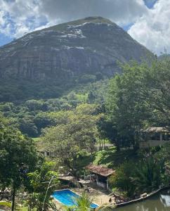 a mountain in the distance with a swimming pool at FLAT 234 Hotel Pedra Rodeadouro in Bonito