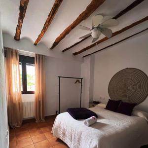 a bedroom with a bed and a ceiling fan at Casa Rural Caballeriza in Hinojares