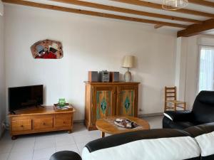 a living room with a couch and a tv and a table at 304 - Jolie maison 4 chambres à 1 kilomètre de la plage in Frehel
