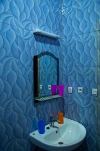 キガリにあるTWINKLE Appartmentsの青いバスルーム(シンク、鏡付)