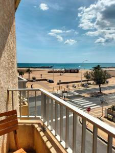 a balcony with a view of a beach and the ocean at Hôtel de la Mer in Valras-Plage