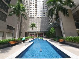 una piscina en medio de un edificio con palmeras en GoldView 2BRs apartment with Free pool-Pick up for booking 7 days, en Ho Chi Minh