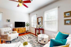 a living room with white furniture and a flat screen tv at Garden Breeze in Gilbert