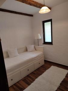 a white couch in a room with a window at Szent Iván Vendégház in Tata