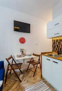a kitchen with a table and a table and chairs at Mikroapartament w centrum in Poznań