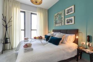 a bedroom with a large bed with blue walls at JTower - Magical Apartments In City Center in Jerusalem