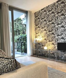 a living room with a couch and a tv at Villa Borghese Green Apartment in Rome +9 photos