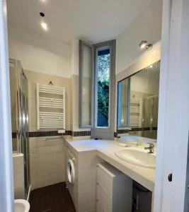 a bathroom with a sink and a toilet and a window at Villa Borghese Green Apartment in Rome