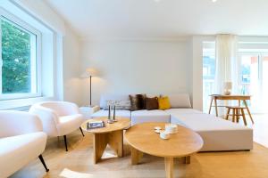 a living room with a white couch and a table at The Nations Bois de la Cambre Flats in Brussels