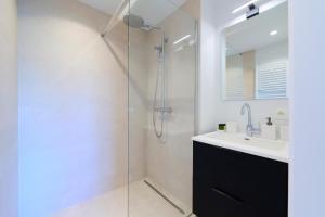 a bathroom with a glass shower and a sink at The Nations Bois de la Cambre Flats in Brussels