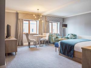 ein Hotelzimmer mit einem Bett und einem Wohnzimmer in der Unterkunft Diamond Coast Hotel in Enniscrone