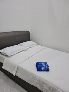 a white bed with a blue pillow on it at The Bunga and The Daun Housestay 2 in Sungai Besar