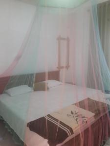 a bedroom with a bed with a mosquito net at WATHSALA HOME VILLA(homestay) in Ella