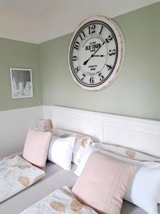 a large clock on the wall above two beds at Ferienwohnung "Glücksplatzerl" in Mondsee