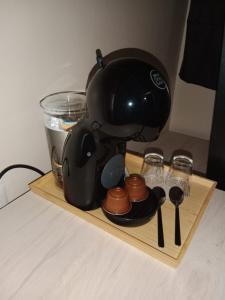 バレンシアにあるパープル ネスト ホステルのコーヒーメーカー(木製トレイ、グラス付)