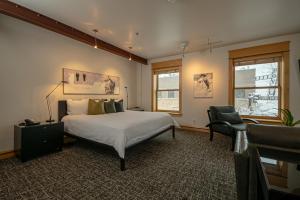 um quarto com uma cama grande e uma cadeira em Hotel Donaldson em Fargo