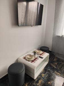Cette chambre comprend une table avec deux tabourets et une table avec des assiettes. dans l'établissement Súkromný luxusný apartmán, à Hlohovec