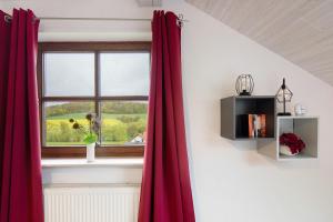 a red curtain in a room with a window at Landharmonie Knüll in Frielendorf