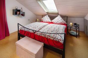 a bedroom with a bed with a red comforter at Landharmonie Knüll in Frielendorf