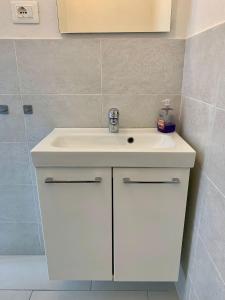 uma casa de banho com um lavatório branco e um chuveiro em casa fiorella em San Bernardino